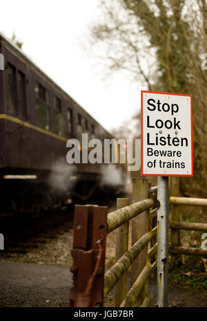 Smettere di guardare ascoltare segno in un sentiero della traversata del South Devon Railway. Foto Stock