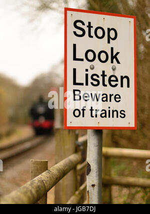 Smettere di guardare ascoltare segno in un sentiero della traversata del South Devon Railway. Foto Stock