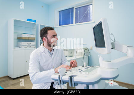 Ritratto di un pensiero medico vicino sceen di apparecchiature medicali. Foto Stock
