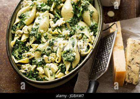 Gli spinaci jumbo seashell pasta con parmigiano e formaggio blu forno pronto cuocere Foto Stock