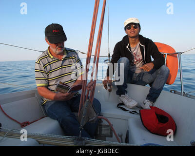 Uomo al timone di una barca a vela, Binic , Cotes-d'Armor, Bretagne, Bretagna, Francia, Europa Foto Stock