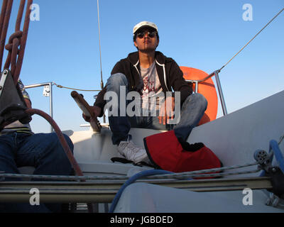 Uomo al timone di una barca a vela, Binic , Cotes-d'Armor, Bretagne, Bretagna, Francia, Europa Foto Stock