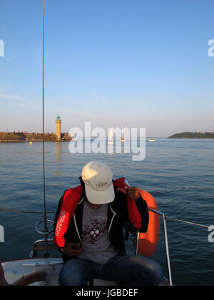 Uomo al timone di una barca a vela, Binic , Cotes-d'Armor, Bretagne, Bretagna, Francia, Europa Foto Stock