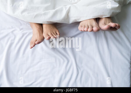 I piedi di un giovane dormendo fianco a fianco Foto Stock