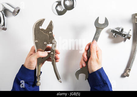 Sovraccarico di plumber le mani al lavoro Foto Stock
