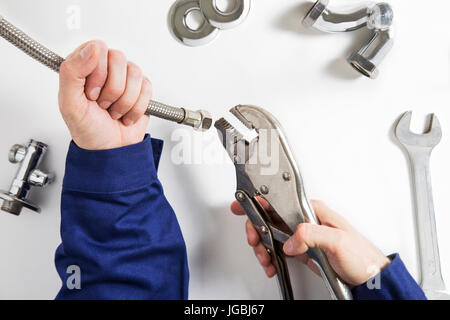 Sovraccarico di plumber le mani al lavoro Foto Stock