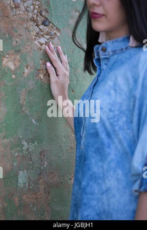 In prossimità di una donna di mano tocca il muro esterno Foto Stock