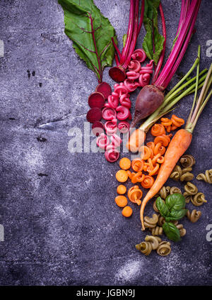 Pasta colorata con carote, barbabietole e basilico. Vista superiore Foto Stock