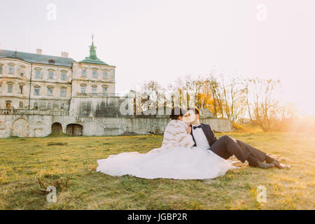 Picnic romantico tra lo sposo e la sposa nel giardino del vecchio castello durante il tramonto. Close-up. Foto Stock