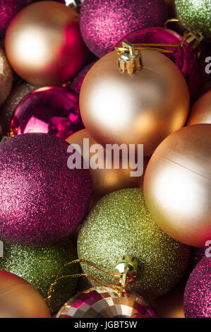 Una selezione di rosa, verde e oro baubles di Natale, raggruppate e telaio di riempimento, colpo da una posizione elevata. Una miscela di vini spumanti, fa Foto Stock