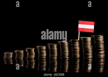 Bandiera austriaca con il lotto di monete isolati su sfondo nero Foto Stock