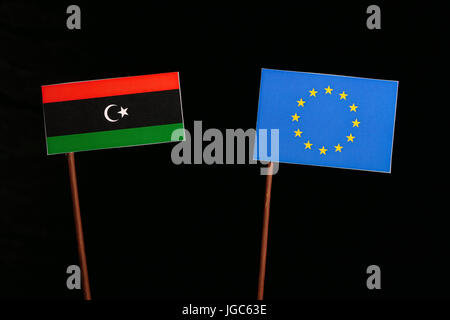 Bandiera libica con l Unione Europea (UE) bandiera isolati su sfondo nero Foto Stock