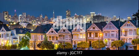 Alamo Square San Francisco dopo il tramonto con la San Francisco Sykline nel retro di massa. Foto Stock