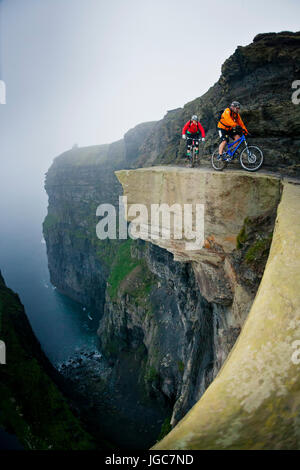 Professional mountain bikers Hans Rey e Steve Peat cavalcare le scogliere di Moher Foto Stock