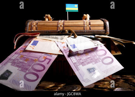 Bandiera ruandese sulla parte superiore della cassa piena di soldi Foto Stock