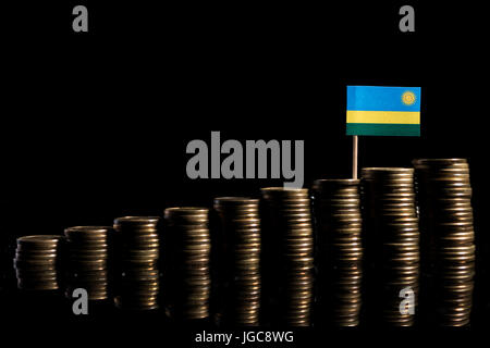 Ruanda bandiera con un sacco di monete isolati su sfondo nero Foto Stock