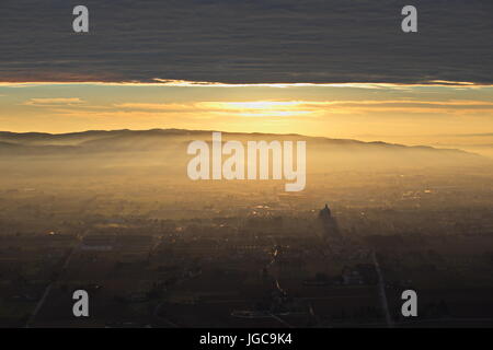 Un epico, vista aerea di Santa Maria degli Angeli città (Assisi) , con il sole che scende attraverso un tetto di nuvole, sporgente Sunray e lightin Foto Stock