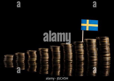 Bandiera svedese con il lotto di monete isolati su sfondo nero Foto Stock