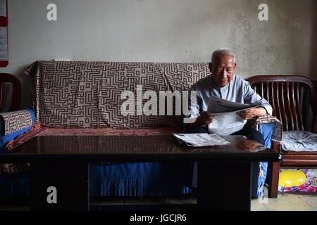 (170706) -- TAIYUAN, Luglio 6, 2017 (Xinhua) -- Veterano Zongru Wang, 94, legge quotidiano a casa nella città di Taiyuan, capitale del nord della Cina nella provincia dello Shanxi, 3 luglio 2017. Wang, nato nel 1923, unite l'esercito cinese nel 1937 durante l'anti-guerra giapponese. Il 7 luglio di quest anno segna l'ottantesimo anniversario dell inizio della Cina di otto anni di resistenza contro l'invasione giapponese. La Cina è stata la prima nazione a lottare contro le forze fasciste. La lotta iniziata il 18 settembre 1931, quando le truppe giapponesi hanno iniziato la loro invasione del nord-est della Cina. Essa è stata intensificata quando il Giappone a piena scala invasione iniziò dopo un c Foto Stock