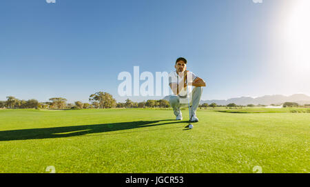 In Pro Golf player volto girato con club in corso. Golfista maschio sul putting green circa per scattare la foto. Foto Stock