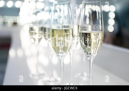 Bicchieri di champagne su sfondo bianco in luci luminose. Fashion show backstage