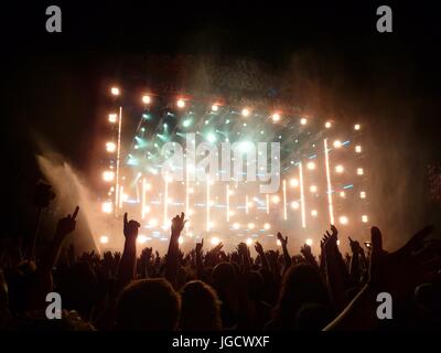 La gente di divertimento presso il concerto all'aperto godendo il festival di musica con le mani in aria Foto Stock