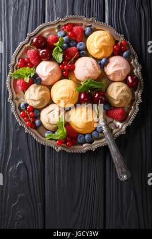 Colorati biscotti frollini con freschi frutti di bosco estate vicino sul tavolo. Vista verticale da sopra Foto Stock