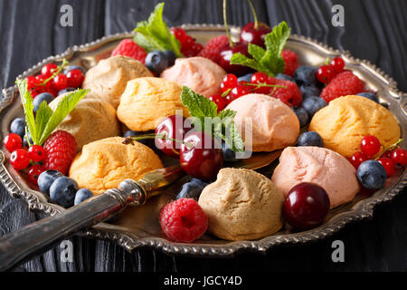 Colorati biscotti frollini con freschi frutti di bosco estate vicino sul tavolo. Posizione orizzontale Foto Stock