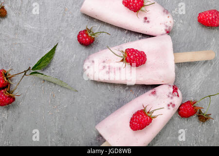 Gelato al lampone su sfondo grigio. tre popsicles. vista dall'alto. in casa Foto Stock