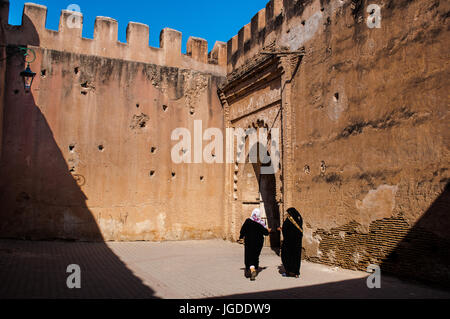 Africa, Marocco, Taroudant, donna musulmana velata a piedi attraverso arco nelle vecchie mura della città. Foto Stock