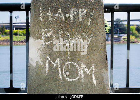 "Happy Birthday Mom' messaggio scritto a mano sul marcatore di cemento Foto Stock
