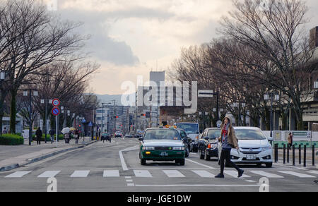 Kyoto, Giappone - Dic 25, 2015. Auto in esecuzione su strada con molti alberi secchi in inverno presso il centro cittadino di Kyoto, Giappone. Foto Stock