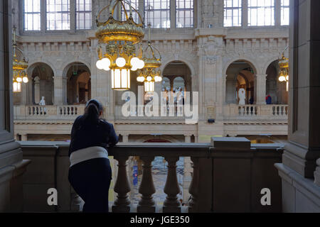 Unica grande donna bambina da sola contemplando la vita guardando oltre il balcone di Kelvingrove Museum Foto Stock