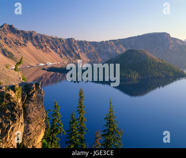 Stati Uniti d'America, Oregon, il Parco nazionale di Crater Lake, Sunrise candelette sul bordo Ovest del cratere del lago con Hillman Peak (sinistra) e Llao Rock (destra)affacciato sulla procedura guidata Islan Foto Stock