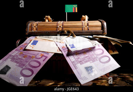 Bandiera dello Zambia sulla parte superiore della cassa piena di soldi Foto Stock