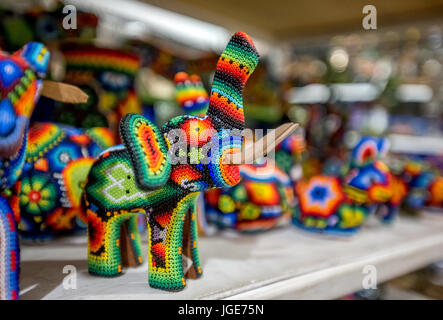 Un tradizionale Huichol (o) Wixaritari bordato arte elephant figura in vendita in Puerto Vallarta, un esempio di arte etnica di queste popolazioni indigene. Foto Stock