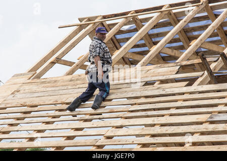 Un uomo lavora per la costruzione di un tetto in legno nella regione Maramures, Romania Foto Stock