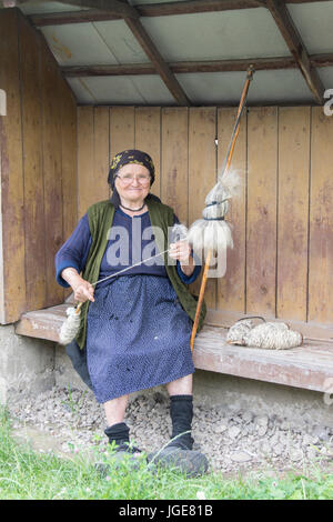 Una donna la filatura della lana con un metodo tradizionale della regione Maramures Foto Stock