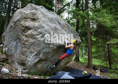 Outdoor sport attività. Rocciatore ragazza salita impegnativa boulder rock. La donna in condizioni estreme di arrampicata sportiva. Foto Stock