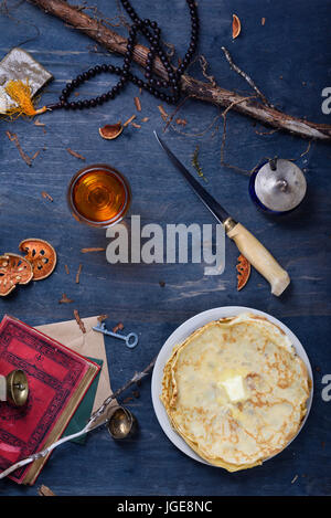 La prima colazione, la pila di frittelle con burro e la bevanda a base di frutta, su un tavolo di legno. In stile vintage, vista dall'alto. Foto Stock