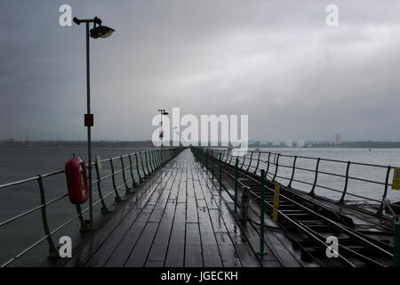 Il lungo molo a Hythe nel sud dell Inghilterra con la sua passerella in legno e la linea ferroviaria per il Southampton traghetto che parte dal molo. Nella foto 0 Foto Stock