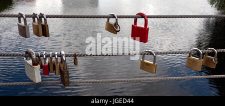 Lucchetti sul lato di un ponte, fili di sicurezza Foto Stock