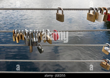 Lucchetti sul lato di un ponte, fili di sicurezza Foto Stock