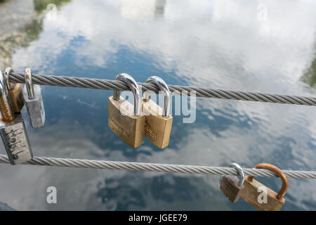 Lucchetti sul lato di un ponte, fili di sicurezza Foto Stock