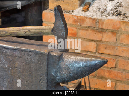 Un'incudine ed un martello nel vecchio smithy closeup Foto Stock