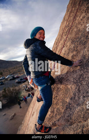 Giovani razza mista donna arrampicata su roccia nel deserto Foto Stock