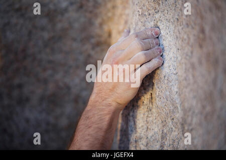 Close up di un rocciatore la mano coperta in gesso di granito di presa Foto Stock