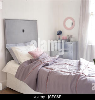 Letto singolo nella camera femminile con rosa e grigio schema colori Foto Stock