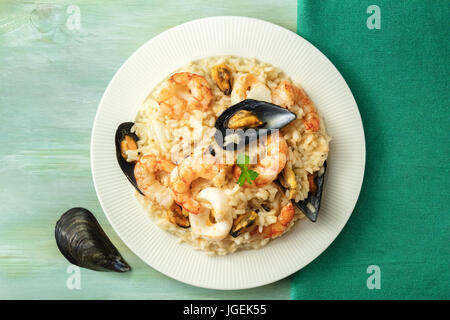 Risotto ai frutti di mare sulla piastra di teal texture con copyspace Foto Stock