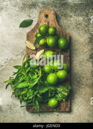 Flatlay di Limette fresche e menta rustico di legno Foto Stock